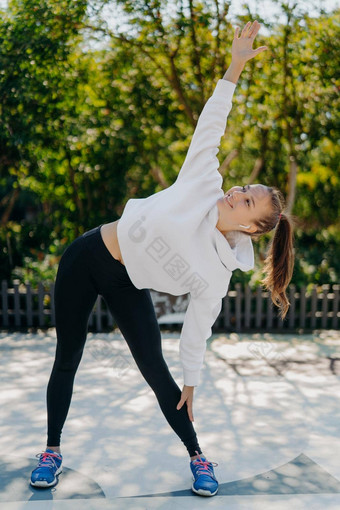 苗<strong>条</strong>的健康的女人练习户外手臂提高了延伸身体运行享受物理<strong>活动</strong>穿着活跃的穿呼吸新鲜的空气听音乐播放列表体育运动概念