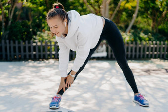 动机年轻的成人女人体育运动定期到达手脚倾斜脚肩膀宽度穿sportsclothes享受培训户外体育活动重量损失