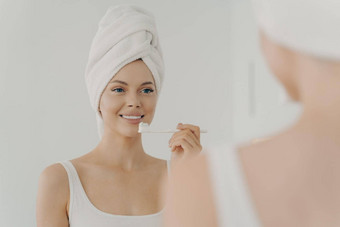健康的美丽的女人毛巾头淋浴露出牙齿的微笑轻轻刷牙牙齿