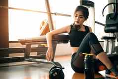 亚洲年轻的女人放松健身健身房体育运动俱乐部中心设备哑铃锻炼强度培训概念美健康的主题体育馆背景