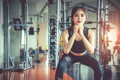 年轻的亚洲女人蹲锻炼脂肪燃烧饮食健身体育健身房体育设备背景美身体构建概念体育俱乐部有氧主题