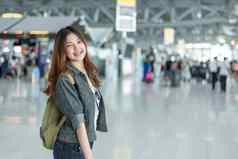 快乐美亚洲女人旅行持有手提箱机场终端人群人乘客背景人生活方式概念旅程世界主题快乐的旅游女孩
