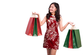 年轻的亚洲美女人穿<strong>旗袍</strong>持有红色的绿色购物袋手势中国人一年节日事件孤立的白色背景假期生活方式概念<strong>旗袍</strong>衣服