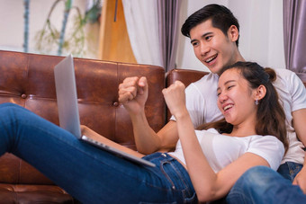 亚洲年轻的夫妻移动PC情人夫妻概念度蜜月婚礼主题室内约会主题