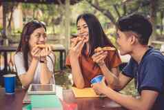 年轻的亚洲人庆祝披萨手食物友谊概念生活方式主题