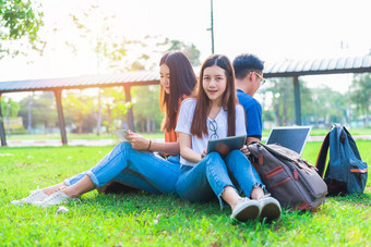 集团亚洲大学学生平板电脑移动PC草场在户外技术教育学习概念未来技术现代娱乐概念象娱乐一样主题