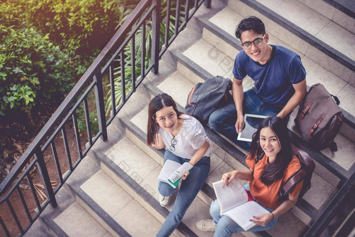 亚洲年轻的校园学生享受辅导阅读书楼梯友谊教育概念校园学校大学主题幸福有趣的学习大学