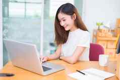 亚洲女人享受笔记本电脑互联网办公室业务市场营销部分时间概念行购物业务成功主题快乐情绪工作工作