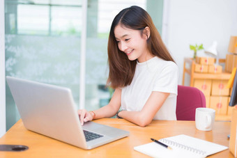 亚洲女人享受笔记本电脑互联网办公室业务市场营销部分时间概念行购<strong>物业</strong>务成功主题快乐情绪工作工作