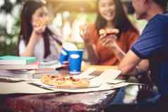 亚洲人享受吃披萨在户外辅导类教育聚会，派对概念食物饮料主题幸福生活方式主题