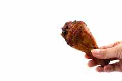 手捕捉烤鸡腿美味的烧烤鸡箔孤立的白色背景食物开胃菜概念
