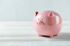 粉红色的小猪银行白色木地板上金融钱储蓄概念复制空间