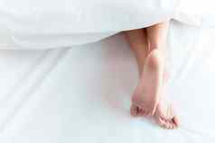 女人脚床上白色毯子睡觉放松概念假期假期主题