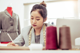 有吸引力的亚洲女时尚设计师工作首页办公室车间时尚的时尚达人女人创建布设计集合裁缝缝纫人生活方式占领概念