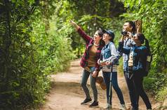 集团亚洲朋友团队冒险徒步旅行野营森林家庭旅行放松徒步旅行小道活动野生生活概念女人指出树天空复制空间