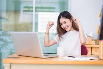 亚洲女人享受笔记本电脑互联网办公室业务市场营销部分时间概念行购物业务成功主题快乐情绪完成了工作工作