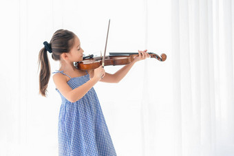 可爱的女孩玩小提琴卧室白色窗帘背景音乐的人生活方式教育娱乐概念亚洲音乐家小提琴家孩子们爱好休闲首页