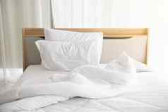 白色恢复原状床上早....阳光白色窗帘背景优雅的首页室内设计奢侈品家具概念在室内生活方式懒惰的活动主题
