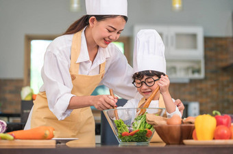 快乐美丽的亚洲女人可爱的男孩眼镜准备烹饪厨房首页人生活方式家庭自制的食物成分概念泰国人生活