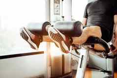 关闭男人。提升重量腿伸展运动肌肉健身健身房私人公寓背景体育运动人生活方式概念