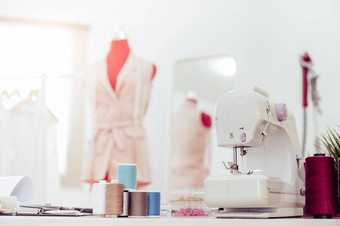 特写镜头缝纫机时尚设计师展厅工作室车间背景集合粉红色的柔和的女衣服设计裁缝缝纫概念裁缝现代房间室内