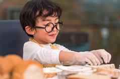 肖像可爱的亚洲幸福男孩感兴趣烘焙面包店有趣的首页厨房人生活方式家庭自制的食物成分概念烘焙圣诞节蛋糕饼干