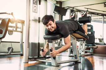 亚洲体育运动男人。伸展运动提升重量腿面对伸展运动肌肉健身健身房公寓背景体育运动人生活方式概念
