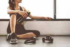 女人哑铃设备锻炼生活方式锻炼健身房健身打破放松体育运动培训蛋白质摇瓶背景健康的生活方式健身运动员肌肉