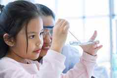 科学家女孩老师下降解决方案物质液体吸管测试管实验室教室教育科学微纳米技术e-healthcare医疗概念