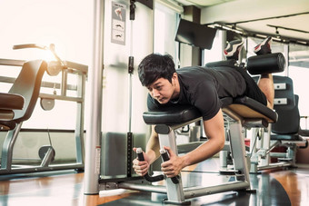 亚洲体育运动男人。伸展运动提升重量腿面对伸展运动肌肉健身健身房公寓背景体育运动人生活方式概念腿旋度的姿势
