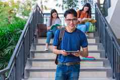 亚洲年轻的校园学生享受辅导阅读书楼梯友谊教育概念校园学校大学主题幸福有趣的学习大学