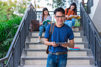 亚洲年轻的校园学生享受辅导阅读书楼梯友谊教育概念校园学校大学主题幸福有趣的学习大学