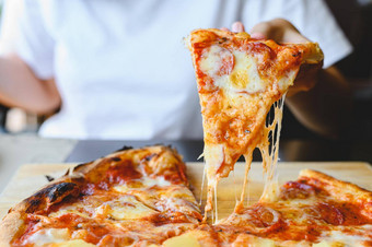 木火干酪披萨片手传统的夏威夷意大利蒜味腊肠披萨风味极佳的菜味道起源意大利餐厅木质的烤箱披萨人持有披萨背景