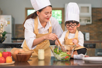 快乐美丽的亚洲女人可爱的男孩眼镜准备烹饪厨房首页人生活方式家庭自制的食物成分概念泰国人生活