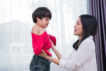 年轻的亚洲妈妈穿着儿子服装准备<strong>学校</strong>妈妈。儿子概念快乐家庭首页甜蜜的首页<strong>主题</strong>学前教育回来<strong>学校主题</strong>