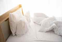 白色恢复原状床上早....阳光白色窗帘背景优雅的首页室内设计奢侈品家具概念在室内生活方式懒惰的活动主题