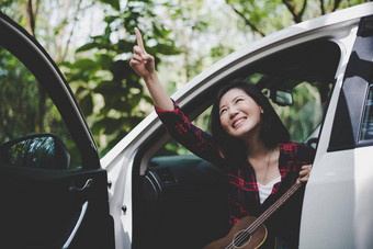 美亚洲女人指出有趣的在户外夏天尤克里里琴白色车旅行摄影师概念赶时髦的人风格只有女人<strong>主题</strong>生活方式幸福生活<strong>主题</strong>