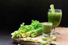 混合芹菜汁喝玻璃群新鲜的芹菜茎木表格叶子黑色的背景食物成分健康的蔬菜新鲜Herbal节食