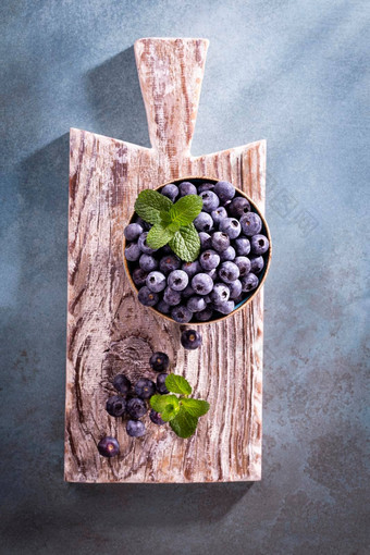碗新鲜的<strong>蓝莓</strong>乡村木董事会有机食物<strong>蓝莓</strong>薄荷叶健康的生活方式