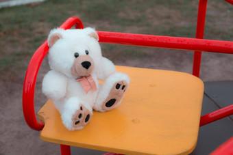 特写镜头泰迪熊坐着孩子们的摇摆不定的红色的概念悲伤损失死亡哀悼孤儿孤独