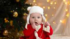 圣诞节孩子相机持有加兰心可爱的女孩红色的衣服白色他圣诞节概念孩子树加兰背景模糊