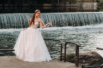 优雅的新娘白色衣服手套站河公园享受自然模型婚礼衣服手套自然公园白俄罗斯