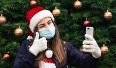 圣诞节在线关闭肖像女人穿圣诞老人老人他医疗面具情感背景圣诞节树冠状病毒流感大流行