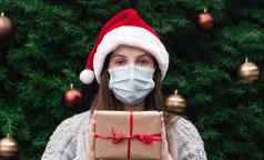 圣诞节面具祝贺你肖像女人穿圣诞老人他毛衣医疗面具给礼物现在盒子红色的丝带圣诞节树散景背景