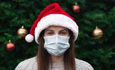 关闭肖像女人穿圣诞老人老人他医疗面具情感背景圣诞节树冠状病毒流感大流行