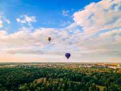 色彩斑斓的热空气气球飞行小欧洲城市夏天日落