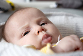 特写镜头肖像新生儿婴儿女孩流口水三个月大婴儿谎言摇篮reskeries牛奶