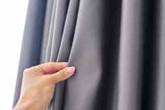 女人的手触碰窗帘灰色的停电织物遮光织物