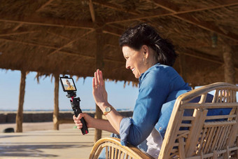中间岁的女人智能<strong>手机网络</strong>摄像头会说话的记录视频桑迪海滩
