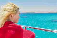 年轻的金发女郎女游艇绿松石珊瑚珊瑚礁红色的海